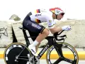 Cyclist in full aerodynamic gear, focused on time trial training, pushing hard on a specialized bike.
