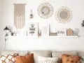 Idee per arredare parete dietro divano: macramè, specchi, quadri con scritte e oggetti decorativi creano un angolo accogliente.