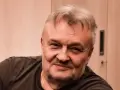 Uśmiechnięty Krzysztof Cugowski, z siwiejącymi włosami i zarostem. Zastanawiasz się, ile lat ma Krzysztof Cugowski?