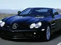 Czarny SLR McLaren pędzi po pustynnej drodze, jego sylwetka lśni w słońcu.