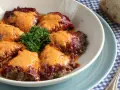 Pimientos rellenos de carne, cubiertos con una cremosa salsa y adornados con perejil fresco. Un plato casero listo para disfrutar.