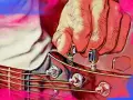 Dłoń stroi gitarę, naciągając struny do idealnego dźwięku a 440 hz.