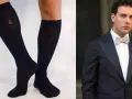 Un uomo elegante con smoking e papillon abbinato a calzini scuri.