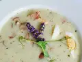 Aromaticzny żurek z kiełbasą i jajkiem, ozdobiony gałązką lawendy i kiełkami.
