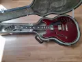 Rote E-Gitarre im Koffer, ein Beispiel für verschiedene E-Gitarrentypen, bereit für den Transport.