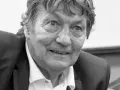 Portret Ryszarda Jedlińskiego w garniturze i białej koszuli. Jego twarz jest lekko uśmiechnięta, a oczy patrzą wprost na widza.