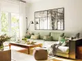 Un espejo grande y decorativo es una excelente idea de qué poner detrás del sofá, aportando amplitud y estilo a la sala.