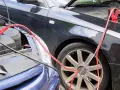 Zwei Autos werden mit Starthilfekabeln verbunden, um die Batterie zu starten.