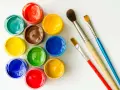 Tarros de temperas de colores vibrantes y pinceles listos para pintar.
