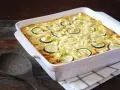 Un délicieux gratin de courgettes, prêt à être dégusté, avec des rondelles de courgettes et des morceaux de poireau dans une sauce crémeuse.
