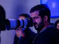 Un fotografo con una Canon EOS scatta foto, pensando a quanto guadagna un fotografo.