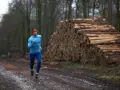 Biegacz w lesie, obok stosu drewna, czerpie siły z czystego powietrza. To jego strefy tlenowe.