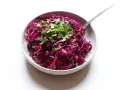 Salade colorée de chou rouge râpé, garnie de coriandre fraîche et de graines de sésame. Une idée simple pour une recette chou rouge savoureuse.