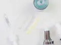 Kwas laktobionowy do jakiej cery? Próbki kosmetyków, w tym serum z kwasem laktobionowym, na białym tle.