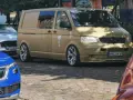 Złoty bus, przeróbka busa na kampera przepisy. Stylowe felgi, naklejki i palma na boku.