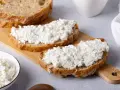 Fette di pane rustico con abbondante ricotta fresca, pronte per gustose ricette con ricotta.