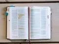 Ein aufgeschlagenes Buch mit Bibeltexten, das die Frage "was bedeutet evangelisch" beleuchtet.