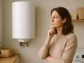 Donna pensierosa guarda lo scaldabagno elettrico, preoccupata per la pressione dell'acqua.