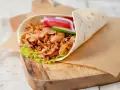 Pyszny kebab w picie z soczystym mięsem, świeżymi warzywami i chrupiącą sałatą, gotowy do zjedzenia.