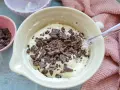 Cremige Masse mit Schokoladenstückchen, bereit für das Herrencreme Rezept. Kleine Schale mit gehackter Schokolade daneben.