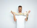 Uśmiechnięty mężczyzna trzyma model kręgosłupa, jakby prezentował jego elastyczność, niczym worek oponowy.