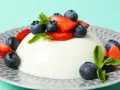 Szybkie ciasto z 4 składników: panna cotta z jagodami i truskawkami, ozdobiona miętą.