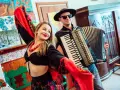 Zespół góralski disco polo w akcji! Wokalistka w barwnym stroju i akordeonista tworzą radosną atmosferę.