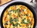 Pyszny omlet z cukinią, pomidorami i szpinakiem, zapieczony w patelni. Idealny na śniadanie lub lekki obiad.