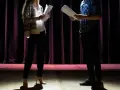 Iga Dzieciuchowicz i partner ćwiczą tekst na scenie. Ciemne zasłony w tle, światło reflektorów.