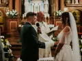 Para Młoda podczas uroczystości ślubu konkordatowego w kościele. Pan Młody w garniturze, Panna Młoda w sukni ślubnej.