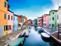 Case colorate lungo un canale a Burano, dove le case sono costruite su palafitte, un'ingegnosa soluzione per capire su cosa è costruita Venezia.