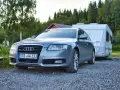 Grauer Audi A6 F4 Kombi mit Wohnwagen im Hintergrund, bereit für den Urlaub.