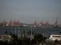 Port w Durban, RPA, z czerwonymi dźwigami portowymi i statkami towarowymi na tle wzgórz. Na pierwszym planie widać maszty jachtów.