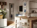 Tavolo in legno con sedie bianche, decorazioni marine e quadri a tema conchiglie: idee originali per arredare casa al mare.