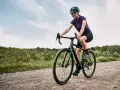 Kobieta na rowerze pokonuje szutrową drogę, wybierając trasę gravel czy cross.