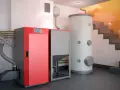 Instalación moderna para cambiar caldera de gas por pellets. Caldera roja, depósito de pellets y acumulador de agua.