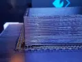Drukarka 3D tworzy obiekt z czarnego materiału PEEK, warstwa po warstwie.