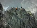 Dwóch alpinistów pokonuje skalisty grzbiet. Jeden z nich zjeżdża na linie, drugi czeka na szczycie. To trudna droga Martina na Gerlach.