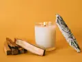 Palosanto, vela encendida y manojo de salvia. Prepara tu espacio para como quemar palo santo y purificar el ambiente.