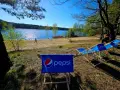 Słoneczny dzień nad jeziorem, leżaki z logo Pepsi czekają na gości turawa camp.