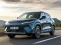 Ciemnozielony samochód elektryczny BYD Atto 2 jedzie po drodze.