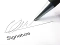 A pen signs a document, finalizing a corporate sponsorship agreement.