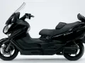 Czarny Suzuki Burgman 650, skuter z wygodnym siedzeniem i dużą szybą. Choć ceniony, ma swoje wady.