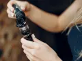 Manos rellenando un cigarrillo electrónico, mostrando las tecnologías sub ohm para una experiencia de vapeo intensa.