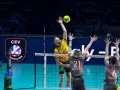 Emocjonujący moment w final ligi mistrzów siatkówka. Zawodnik w żółtej koszulce atakuje, a dwaj gracze w szarych strojach próbują go zablokować.