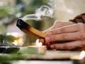 Dym z palo santo unosi się nad płonącą świecą. Zastanawiasz się, palo santo dlaczego nie używać?