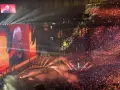 Koncertowa noc z piosenkarką sanah. Ogromna publiczność, światła i ekran z wizerunkiem artystki.