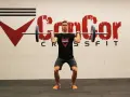 Man i träningskläder förbereder sig för en push press med skivstången i axelhöjd.