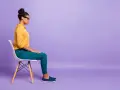 Donna seduta su una sedia, con le mani appoggiate sulle ginocchia, in una posa che suggerisce le **tecniche di grounding** per ritrovare la calma.