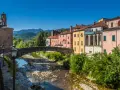 Pontremoli, dove si trova questo pittoresco borgo con case colorate, un ponte ad arco e un fiume.